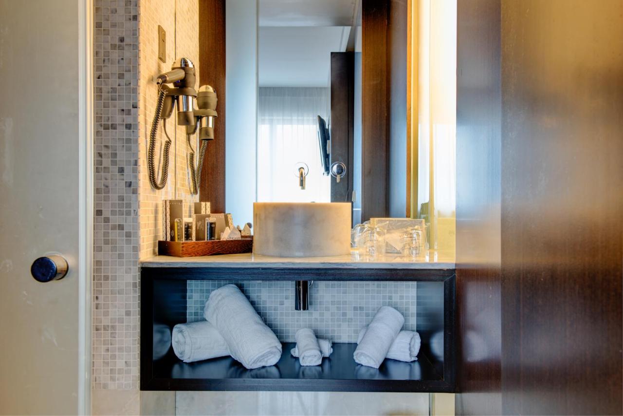 een badkamer met een wastafel en een plank met handdoeken bij VIP Grand Lisboa Hotel & Spa in Lissabon