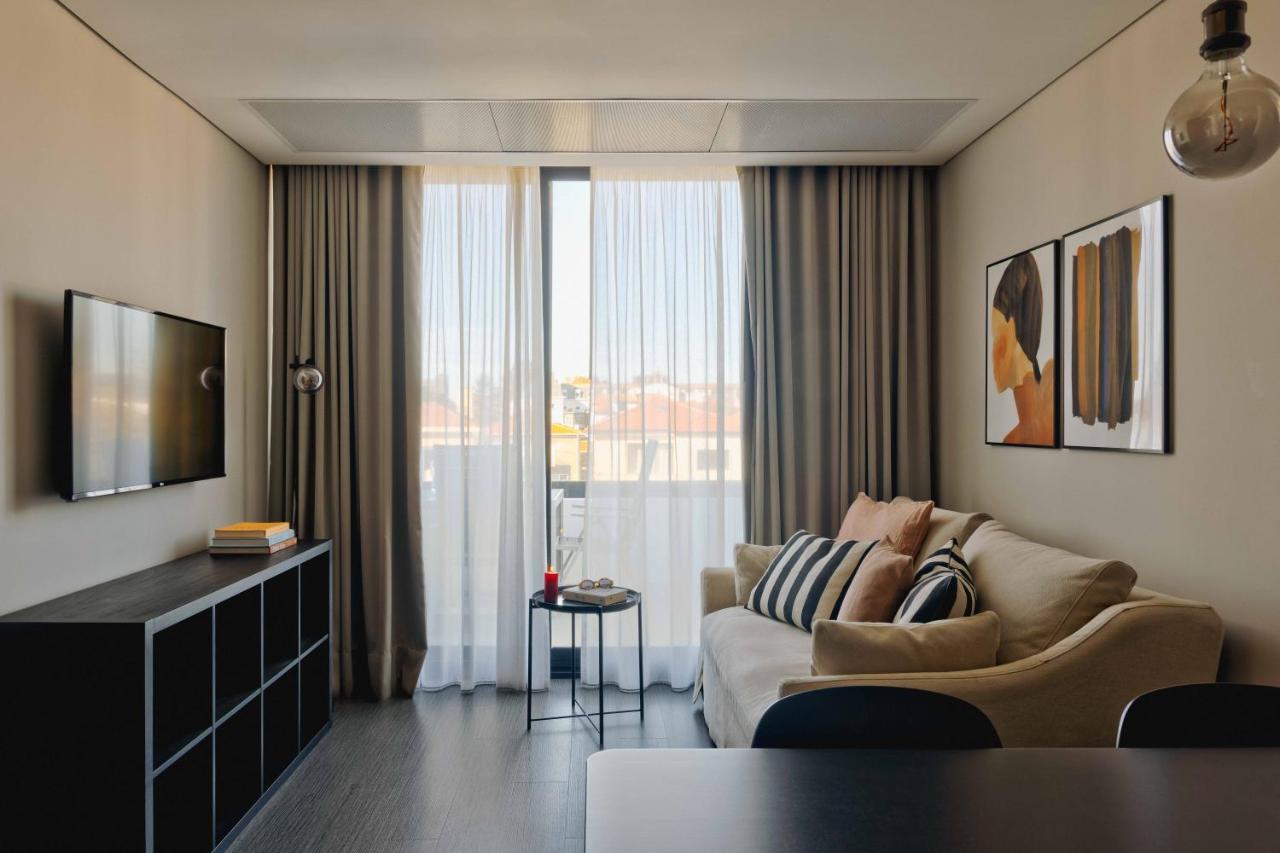 een woonkamer met een bank en een groot raam bij Timbre Boavista in Porto
