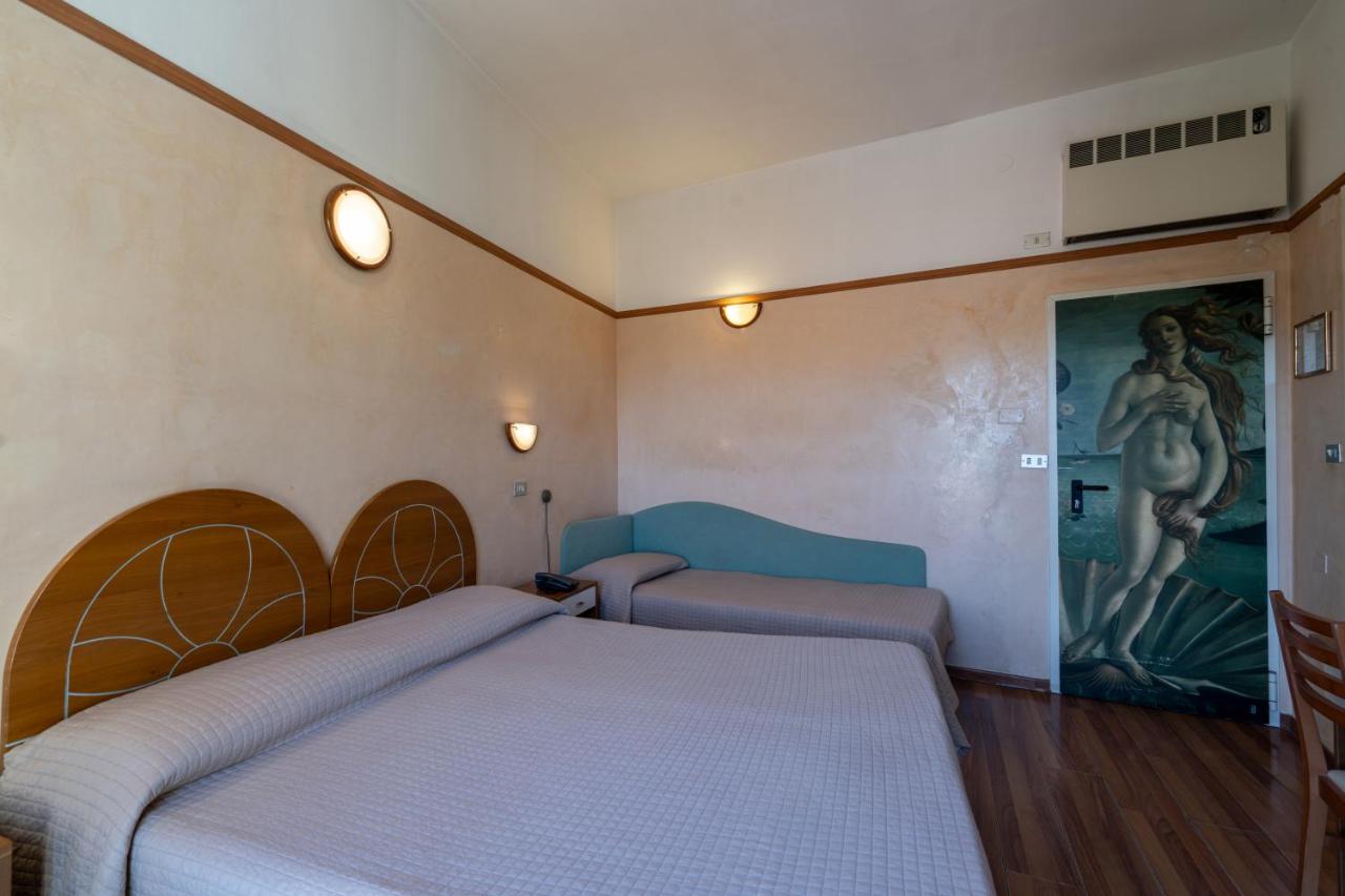 een slaapkamer met twee bedden en een schilderij aan de muur bij Hotel Britannia Rimini Marina centro in Rimini