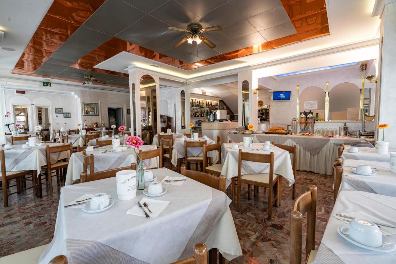 een eetkamer met witte tafels en stoelen bij Hotel Britannia Rimini Marina centro in Rimini