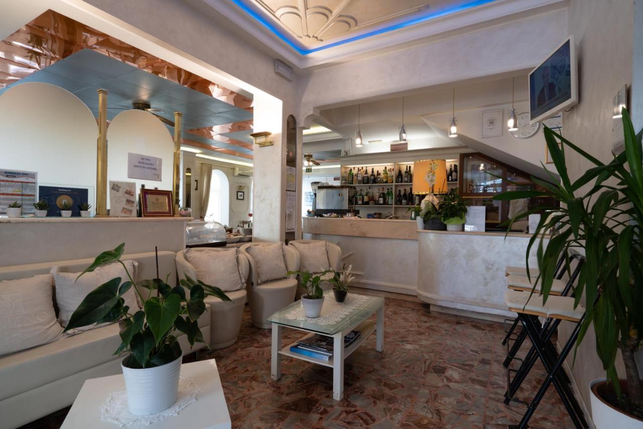 een kamer met een bank en een tafel met planten bij Hotel Britannia Rimini Marina centro in Rimini