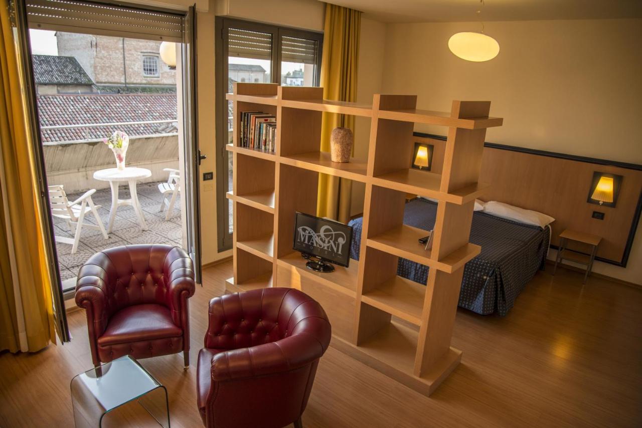 een woonkamer met een boekenkast en een bed bij Hotel Masini in Forlì +29 foto's