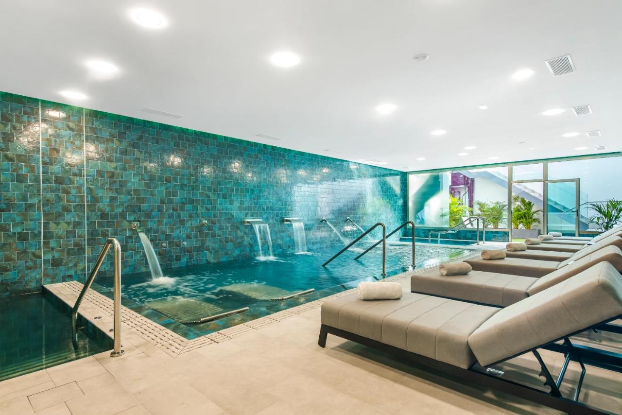 een groot zwembad met een bank in een kamer bij Casas Pepe Apartments & Spa- Adults Only in Playa del Inglés
