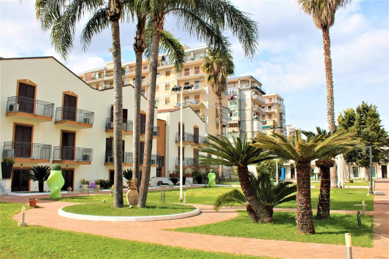 een gebouw met palmbomen ervoor bij Casena Dei Colli, Sure Hotel Collection By Best Western in Palermo