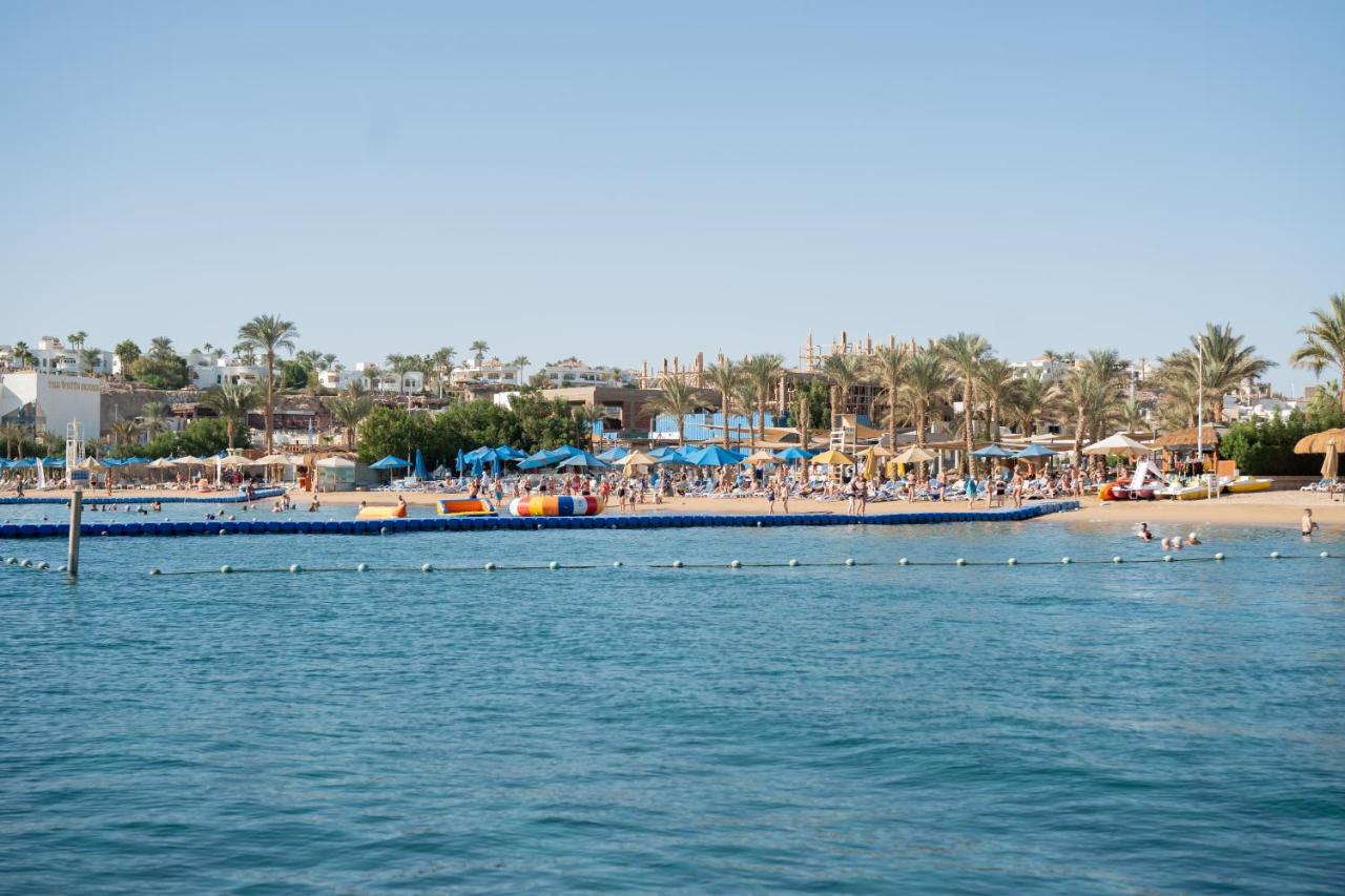 een groep mensen op een strand en een boot in het water bij Maritim Jolie Ville Resort & Casino in Sharm El Sheikh