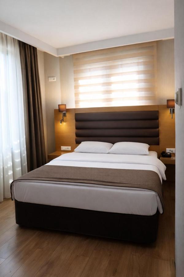een slaapkamer met een groot bed met een houten hoofdbord bij Riva Hotel Taksim in Istanbul