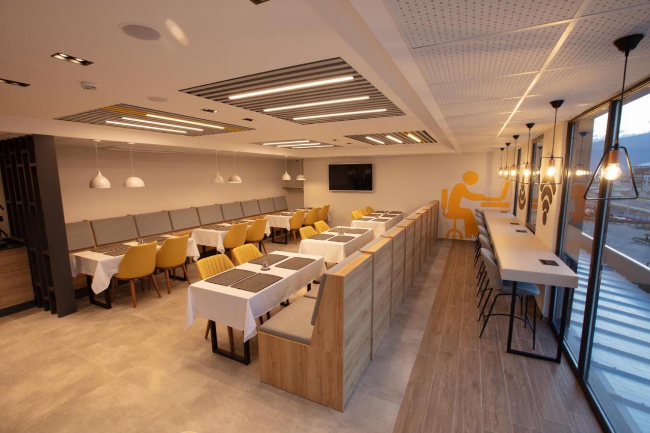 een eetkamer met tafels en gele stoelen bij VALENT OTEL BUSINESS in Mehmetalanı