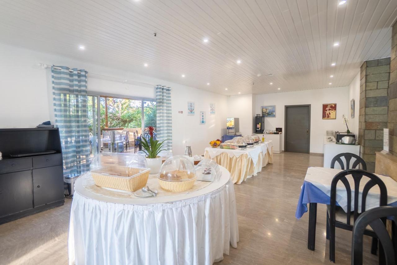 een grote kamer met twee tafels en stoelen en een keuken bij Gorgona Hotel in Amoudara Herakliou