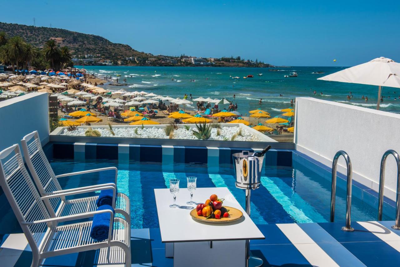 een tafel met een fruitschaal op een balkon met uitzicht op het strand bij I Resort Beach Hotel & Spa in Stalida