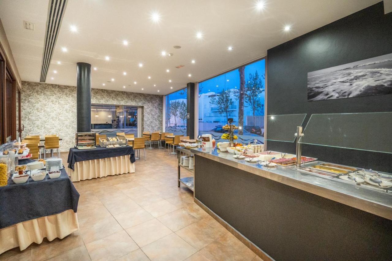 een restaurant met een buffet met tafels en stoelen bij Hotel Andalussia in Conil de la Frontera +48 foto's