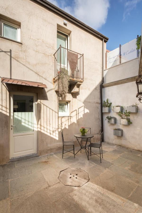 een terras met een tafel en stoelen voor een gebouw bij Il Cortiletto Hotel Maison in Tresnuraghes
