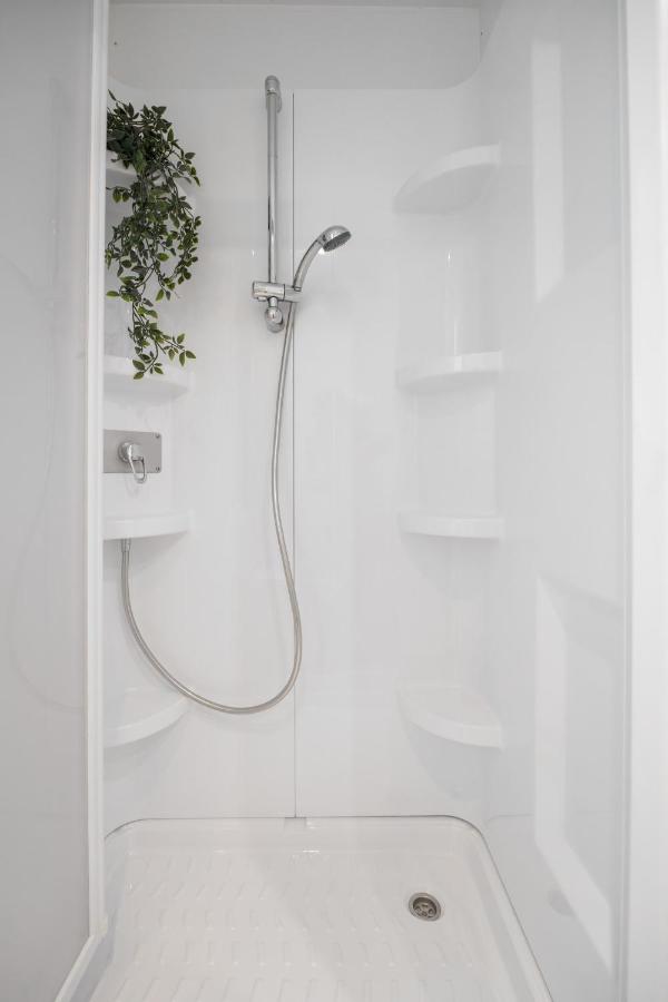 een douche met een slang in een witte badkamer bij Club del Sole Marina Romea Easy Camping Village in Marina Romea