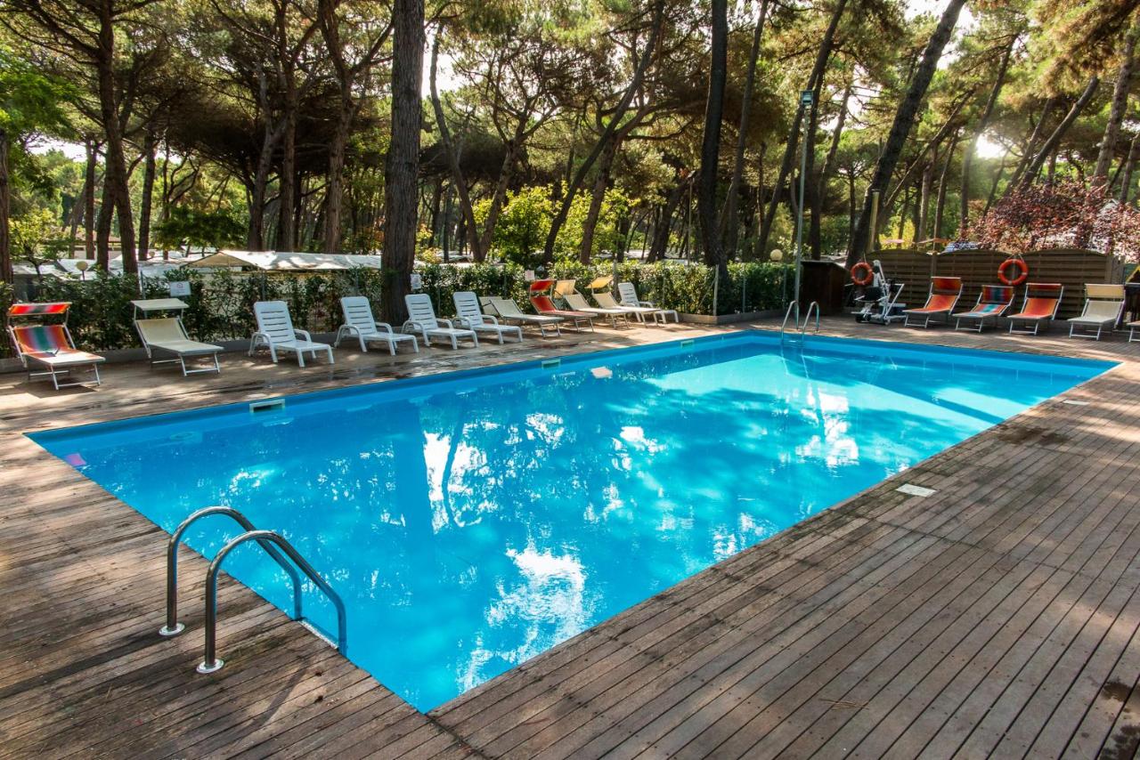 een groot zwembad met stoelen en een tafel bij Club del Sole Marina Romea Easy Camping Village in Marina Romea