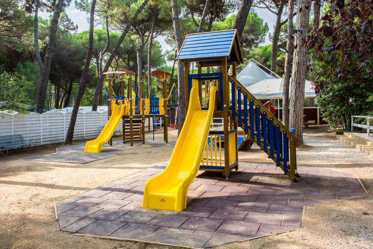 een rij speeltoestellen met een gele glijbaan bij Club del Sole Marina Romea Easy Camping Village in Marina Romea