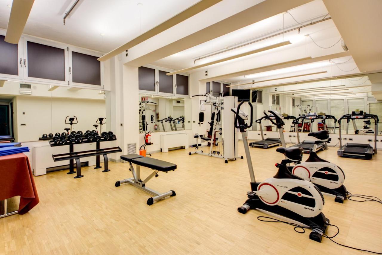 een sportschool met meerdere loopbanden en hometrainers bij Hotel Galileo in Milaan