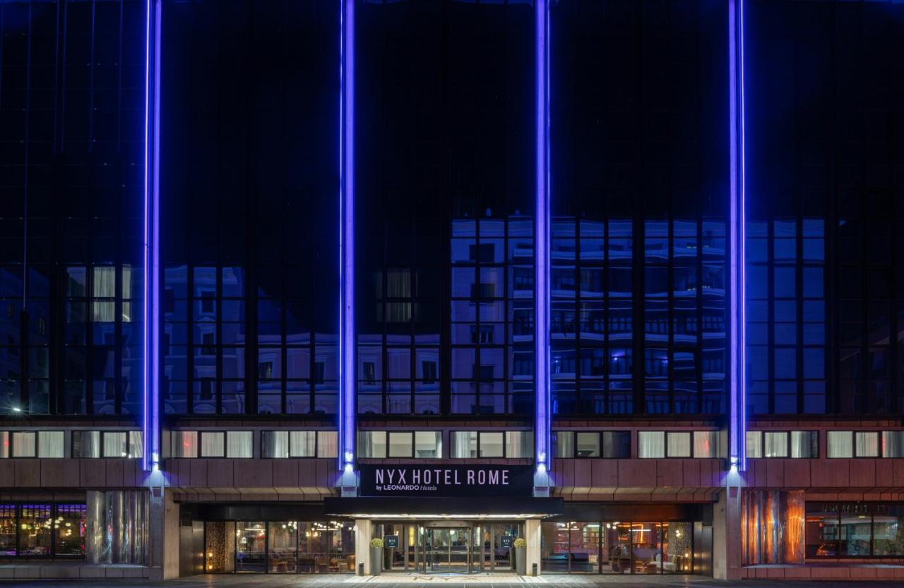 een gebouw met blauwe lichten erop 's nachts bij NYX Hotel Rome by Leonardo Hotels in Rome