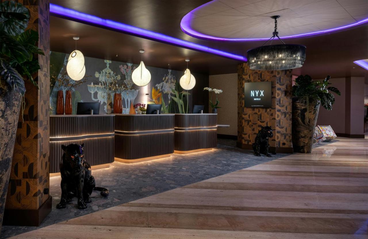 een lobby met twee honden die voor een salon zitten bij NYX Hotel Rome by Leonardo Hotels in Rome