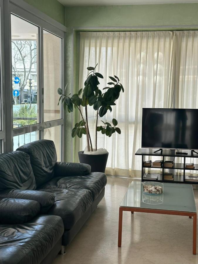 een woonkamer met een zwarte leren bank en een tv bij Hotel Ambra in Rimini