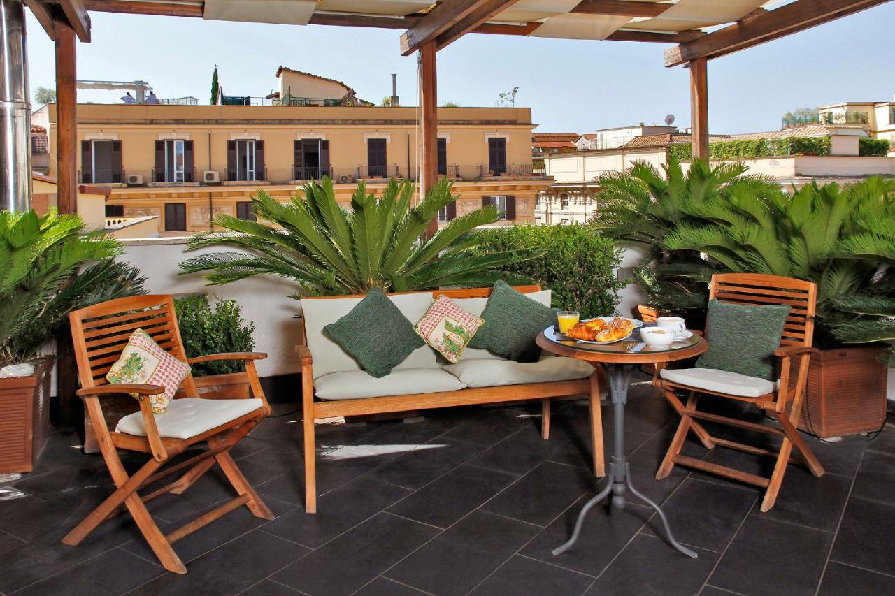 een terras met een tafel en stoelen op een balkon bij Hotel Arcangelo in Rome