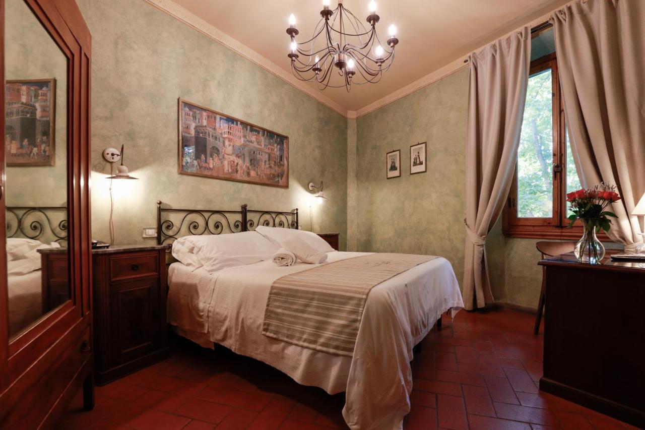 een slaapkamer met een bed en een kroonluchter bij Hotel Bellavista Impruneta in Impruneta