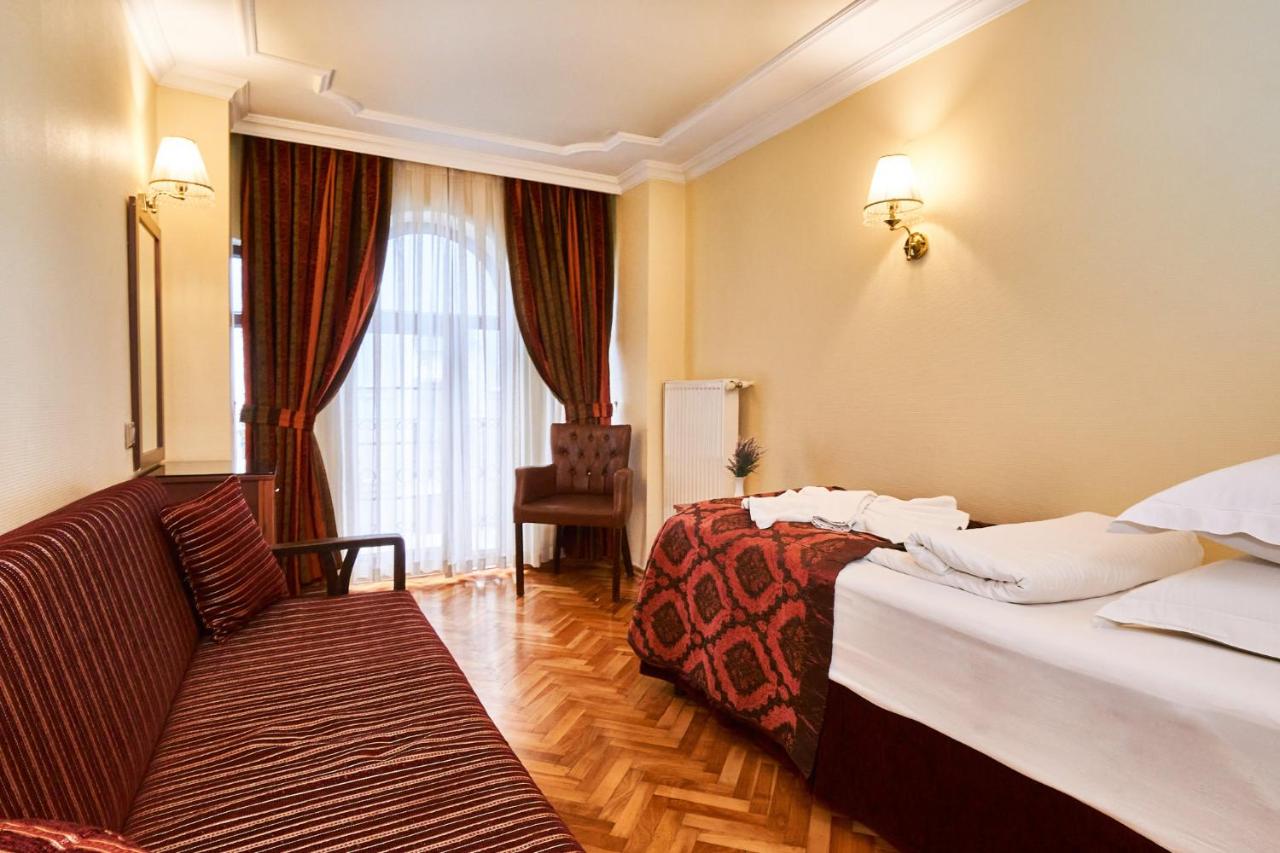 een hotelkamer met twee bedden en een bank bij Amber Hotel & Spa in Istanbul