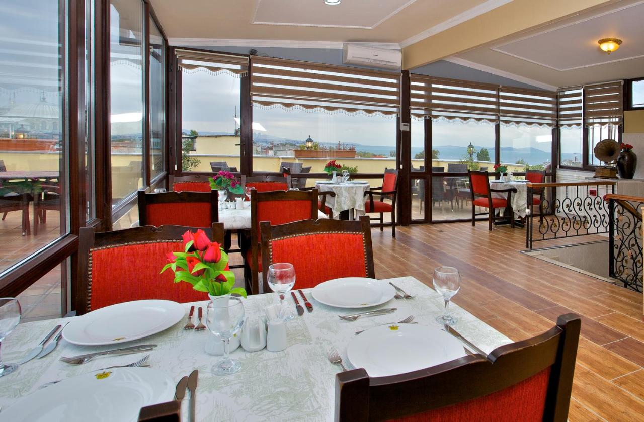 een eetkamer met tafels en stoelen en uitzicht bij Amber Hotel & Spa in Istanbul