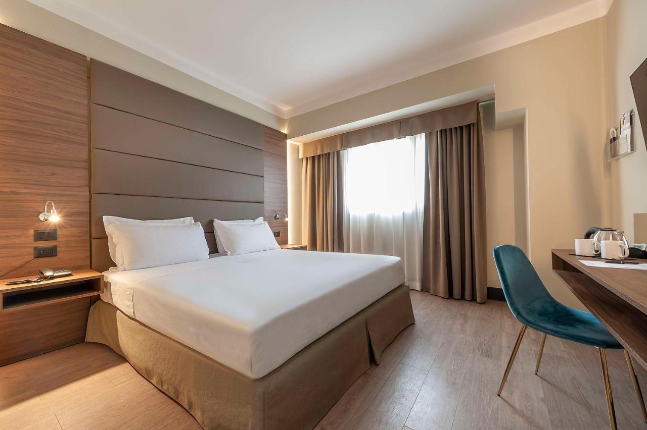 een hotelkamer met een groot bed en een bureau bij Best Western Hotel Quattrotorri in Perugia