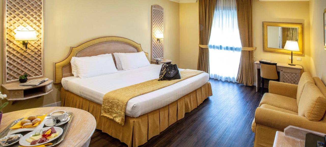 een hotelkamer met een groot bed en een tafel bij Best Western Park Hotel Roma Nord in Fiano Romano