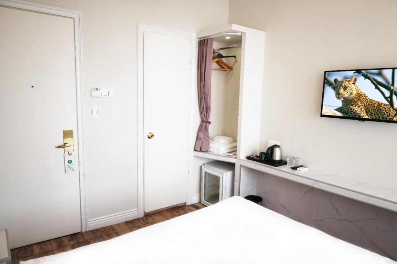 een witte slaapkamer met een bed en een spiegel bij Bakirkoy Tashan Business & Airport Hotel in Istanbul