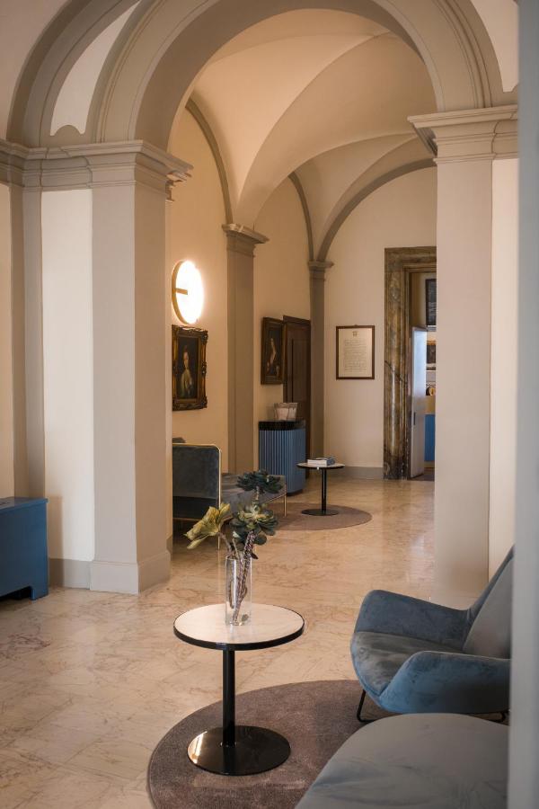 een woonkamer met een vaas met bloemen op een tafel bij Bosone Palace in Gubbio