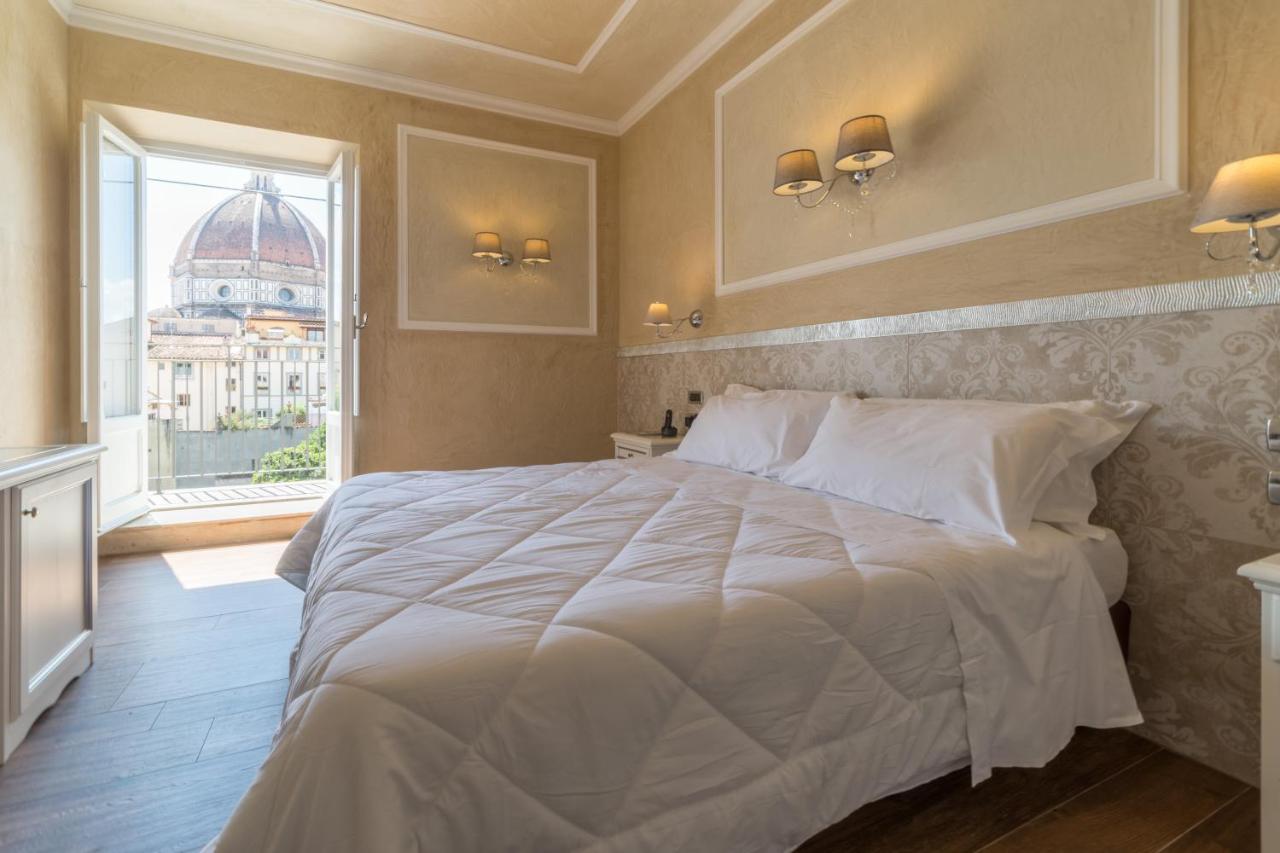 een slaapkamer met een groot wit bed en een raam bij Hotel California in Florence