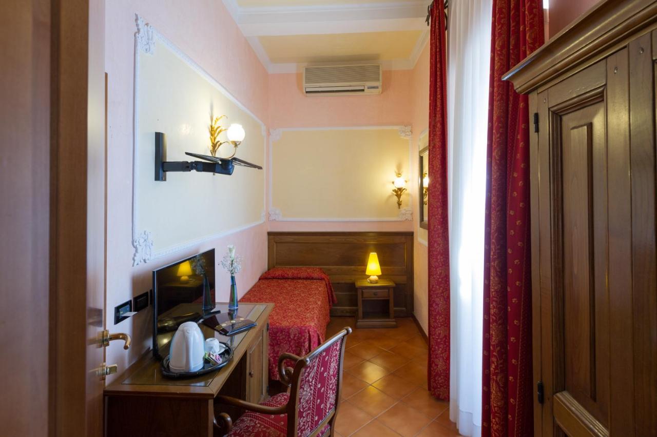 een hotelkamer met een slaapkamer met een bed en een bureau bij Hotel California in Florence