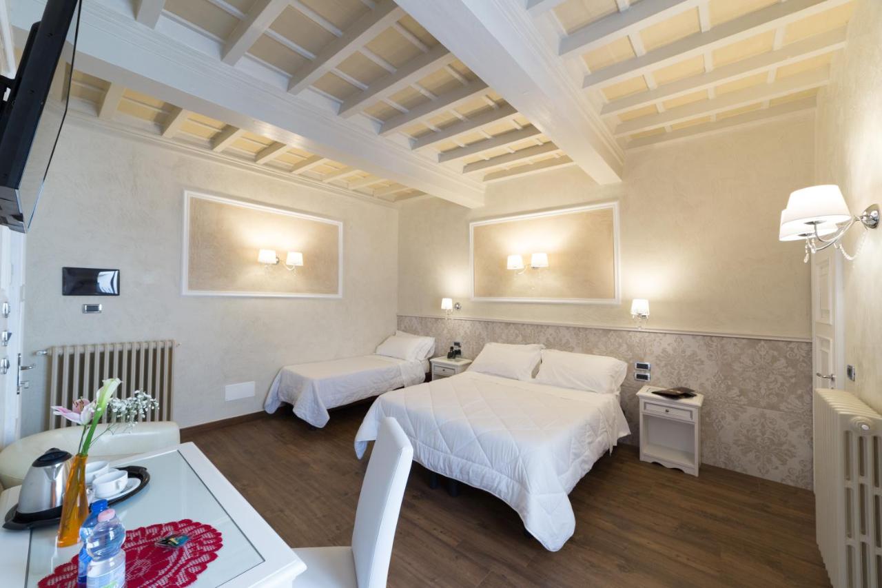 een hotelkamer met twee bedden en een tafel bij Hotel California in Florence +60 foto's