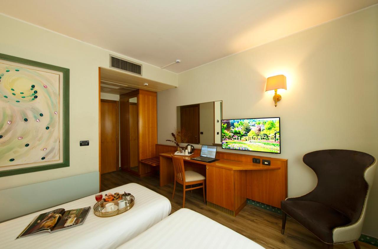 een hotelkamer met een bed, een bureau en een televisie bij Castagna Palace Hotel & Restaurant in Montecchio Maggiore