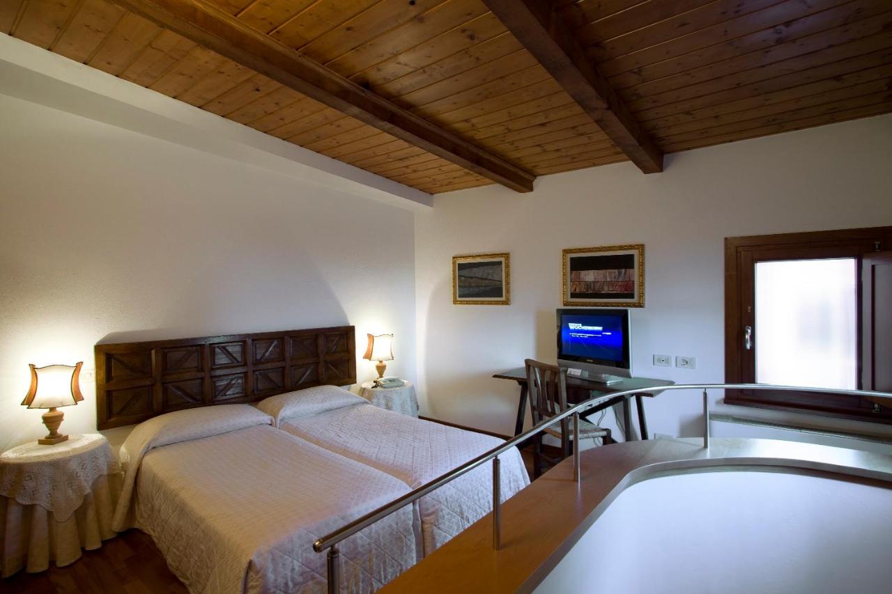 een slaapkamer met een bed, een bureau en een televisie bij Hotel Columbia in Rome