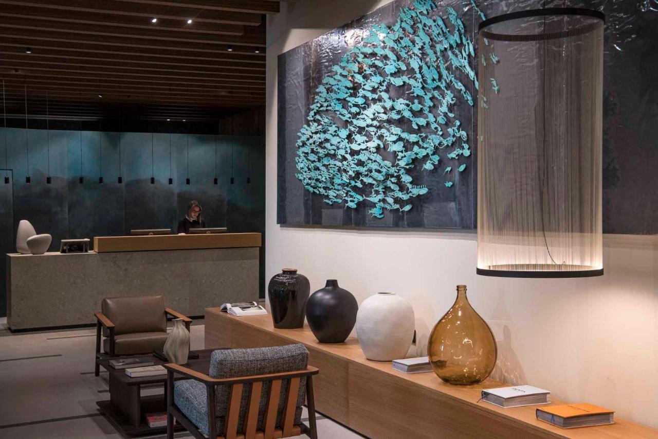 Een lobby met vazen op een tafel en een vrouw op de achtergrond. bij Europa Palace in Sanremo