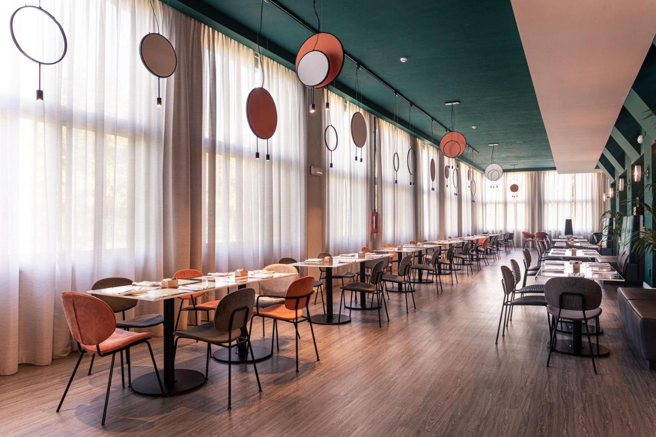 een rij tafels en stoelen in een restaurant bij Quark Hotel Milano in Milaan