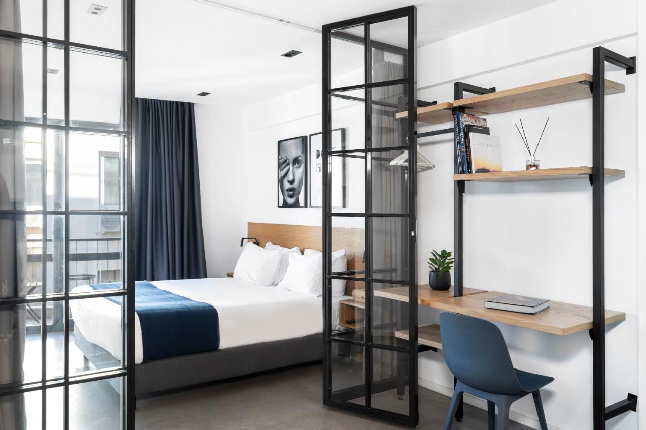 een hotelkamer met een bed, een bureau en een ladder bij PAME House in Athene