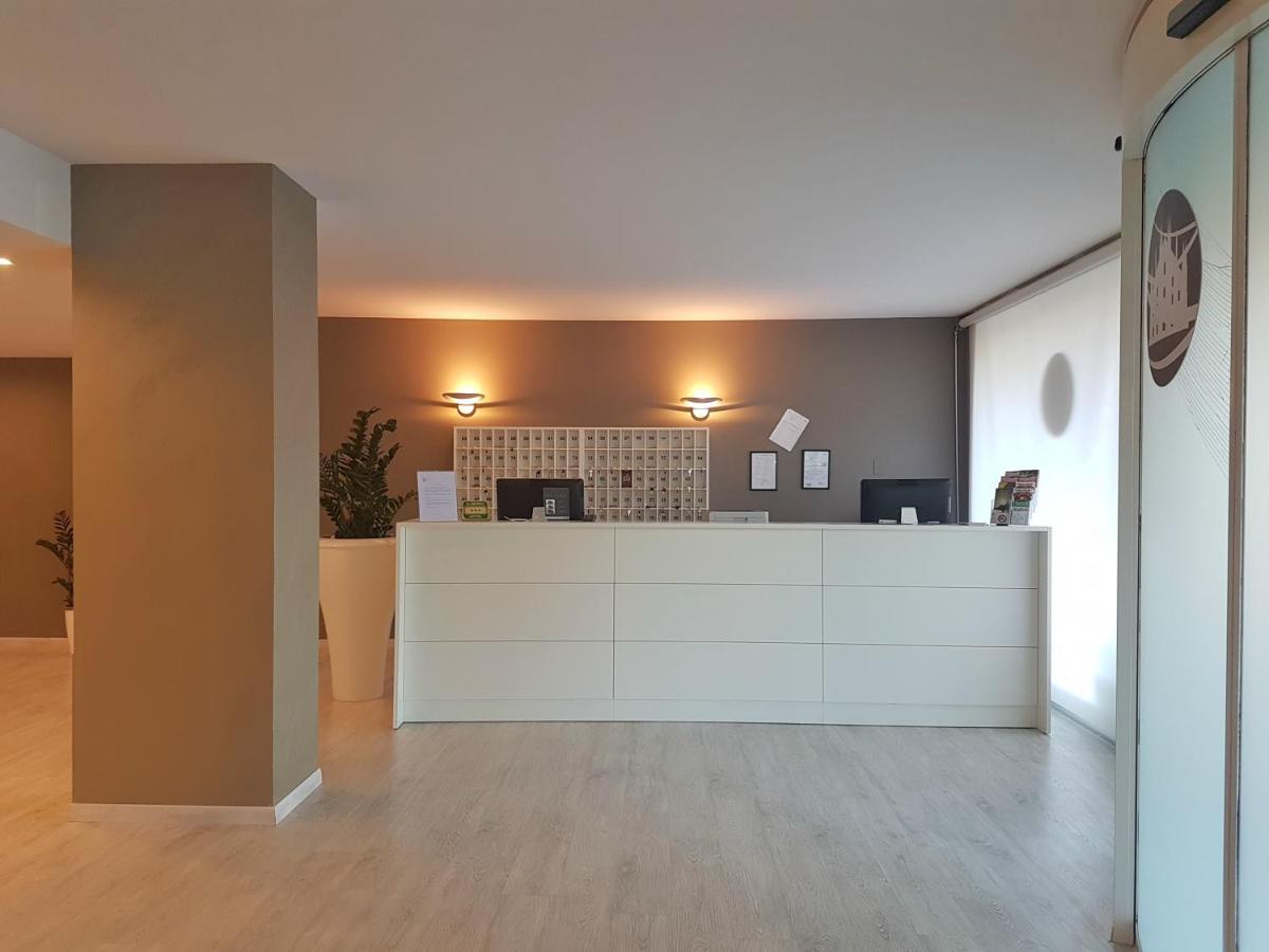 een lege lobby met een receptiebalie in een gebouw bij Plus Welcome Milano in Milaan