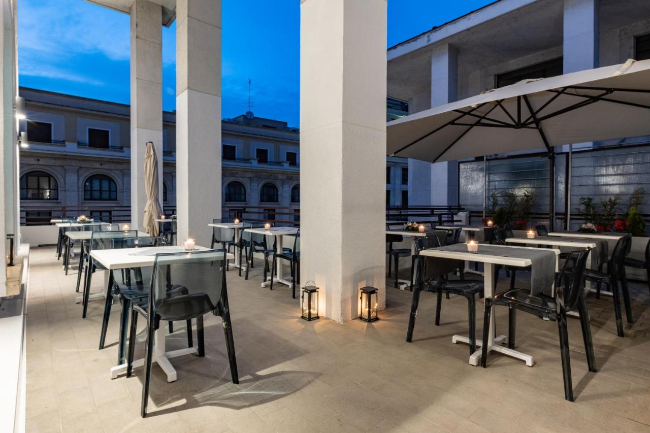 een dakterras met tafels en stoelen op een gebouw bij Concept Terrace Hotel in Rome