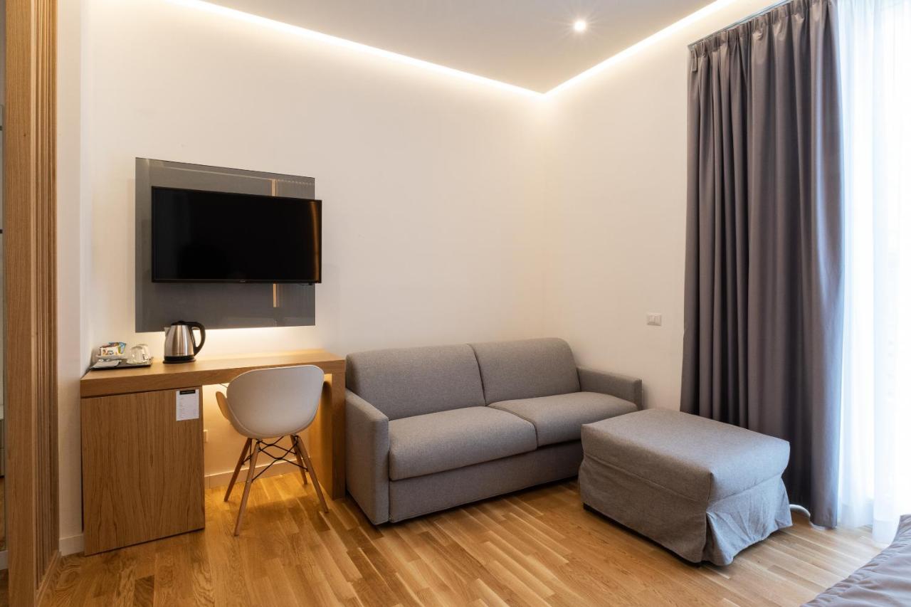 een woonkamer met een bank en een bureau met een tv bij Concept Terrace Hotel in Rome