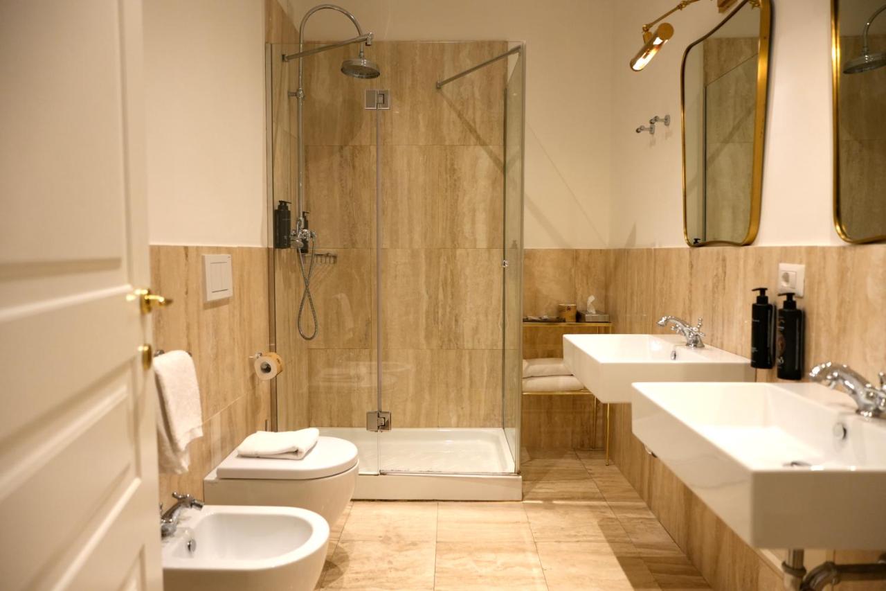 een badkamer met twee wastafels, een toilet en een douche bij The Talent Hotel in Rome