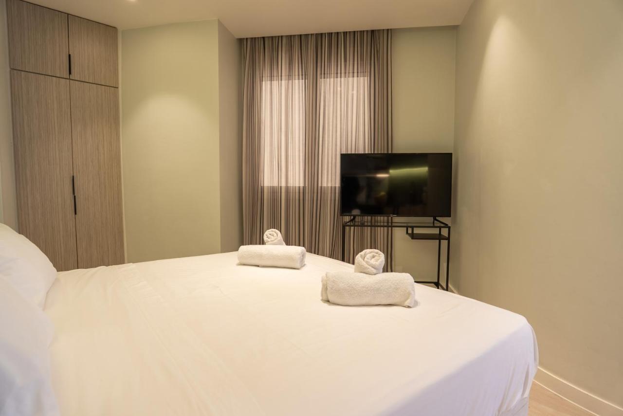 een slaapkamer met een wit bed waarop twee handdoeken liggen bij Athens Urban Nest in Athene