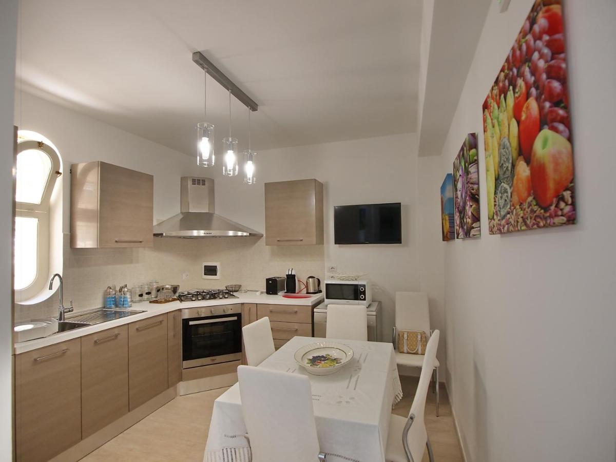 een keuken met een tafel en stoelen en een keuken met een gootsteen bij Le Villette - Taormina in Taormina