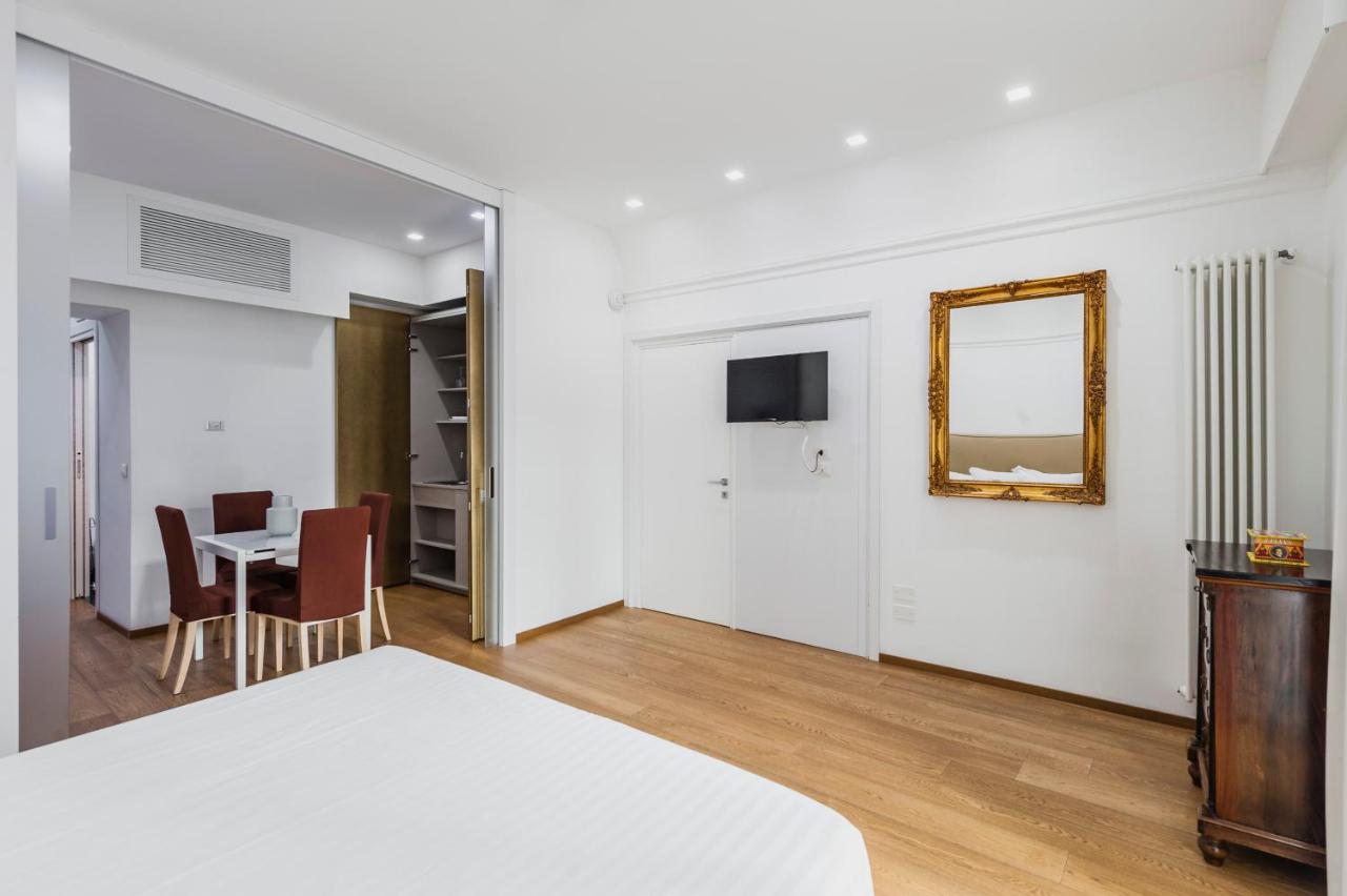 een slaapkamer met een bed, een tafel en een spiegel bij RG7 Apartments in Catania