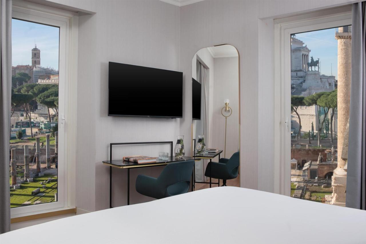 een hotelkamer met een bed en een groot raam bij NH Collection Roma Fori Imperiali in Rome