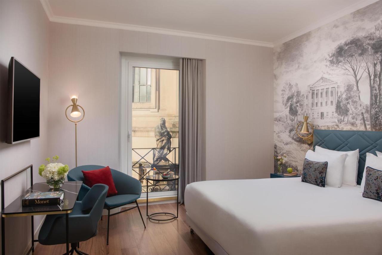 een hotelkamer met een bed, een bureau en een stoel bij NH Collection Roma Fori Imperiali in Rome