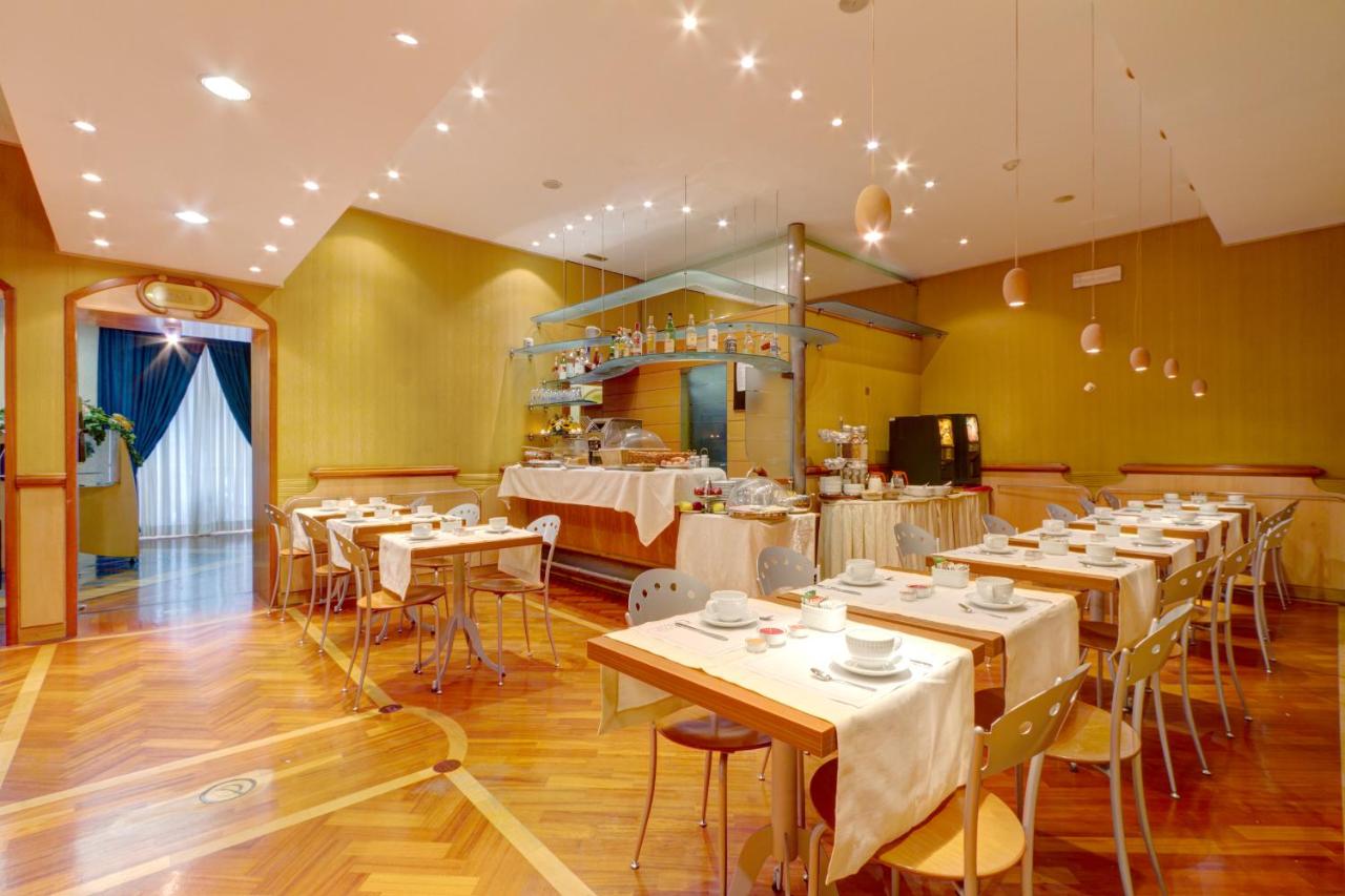 een restaurant met tafels en stoelen in een ruimte bij Hotel Corot in Rome