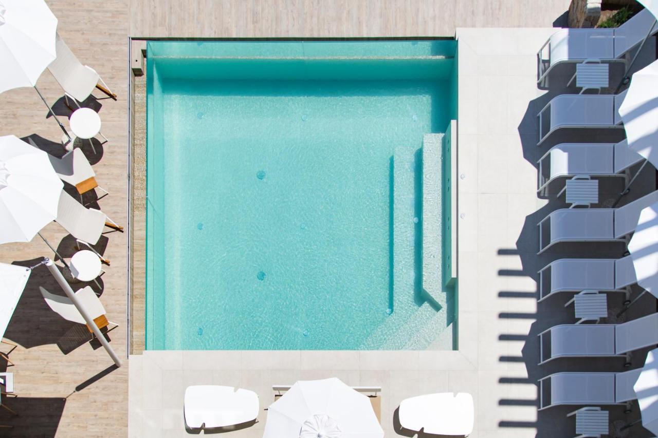 Een bovenaanzicht van een zwembad met ligstoelen. bij Sandalia Boutique Hotel - Adults Only in Cannigione