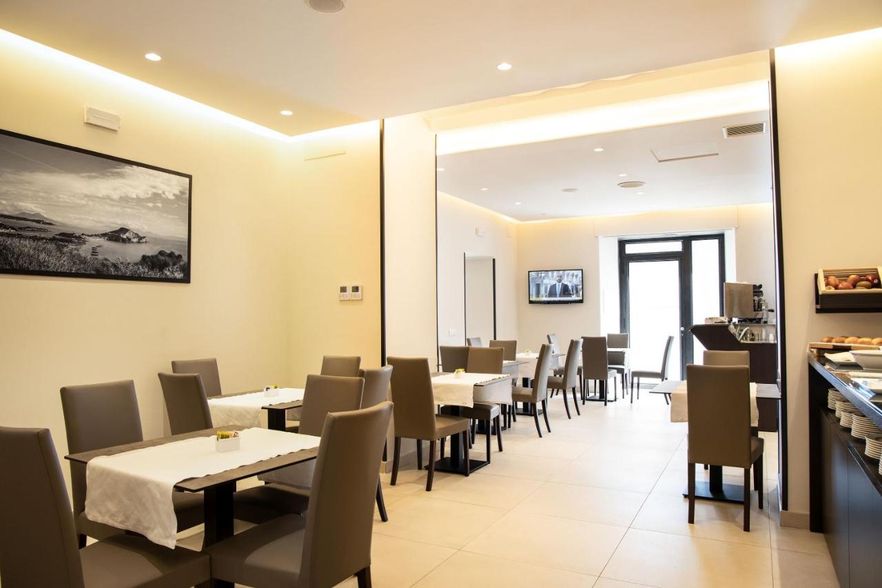 een eetkamer met tafels en stoelen bij Hotel Palazzo Argenta in Napels